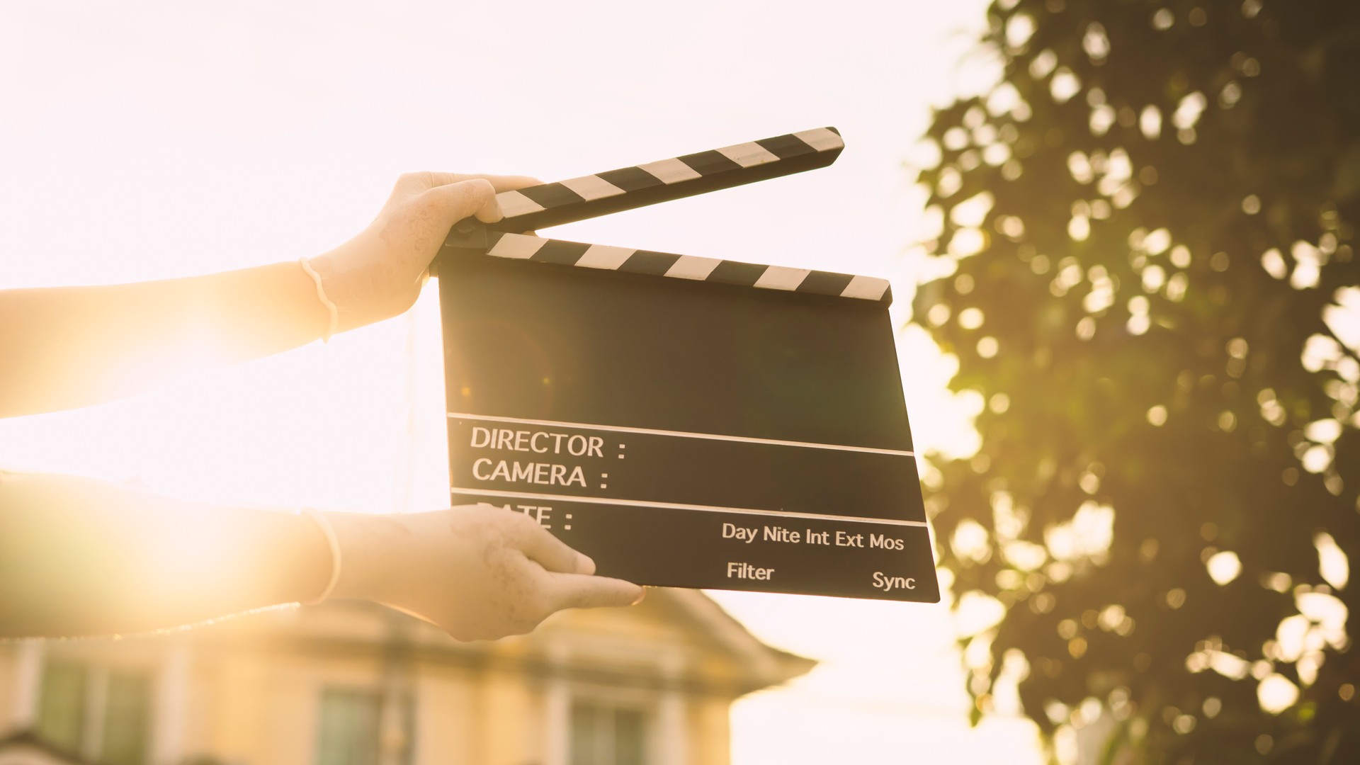 Filmschiefer auf Frauenhänden im Sonnenuntergang. Storytelling und New Age Filming Industriekonzept.